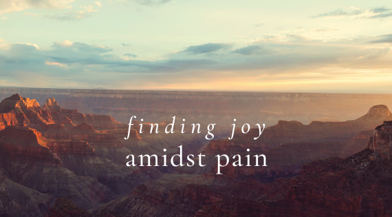 Person sitting alone view of mountains and a sunset, reflecting on emotions and embracing pain. overlay of text that reads "finding joy amidst pain"